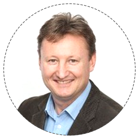 Thirty five year old female executive in business attire, sitting at desk in contemporary office setting with laptop and documents